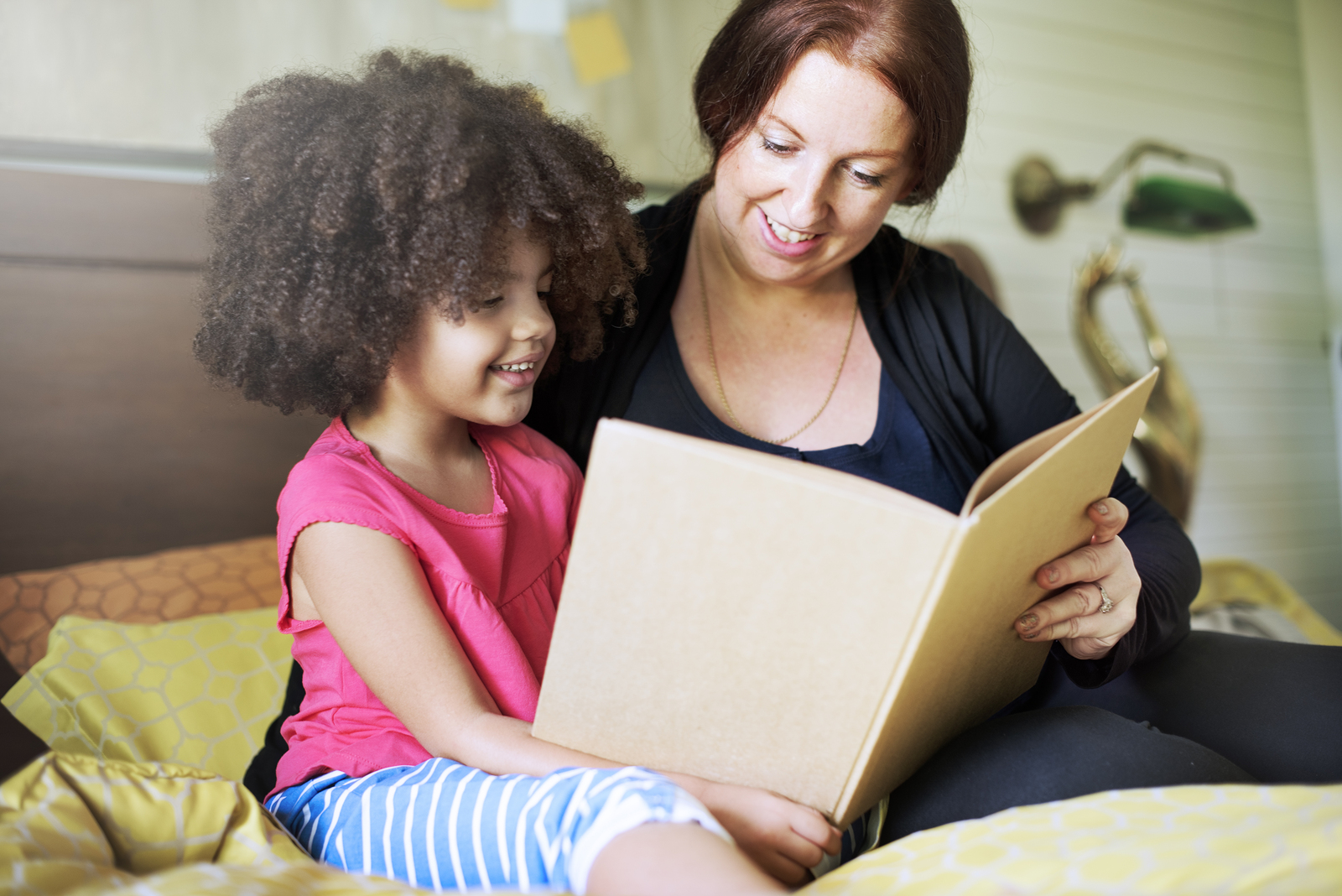 Daughter reading a book with parent